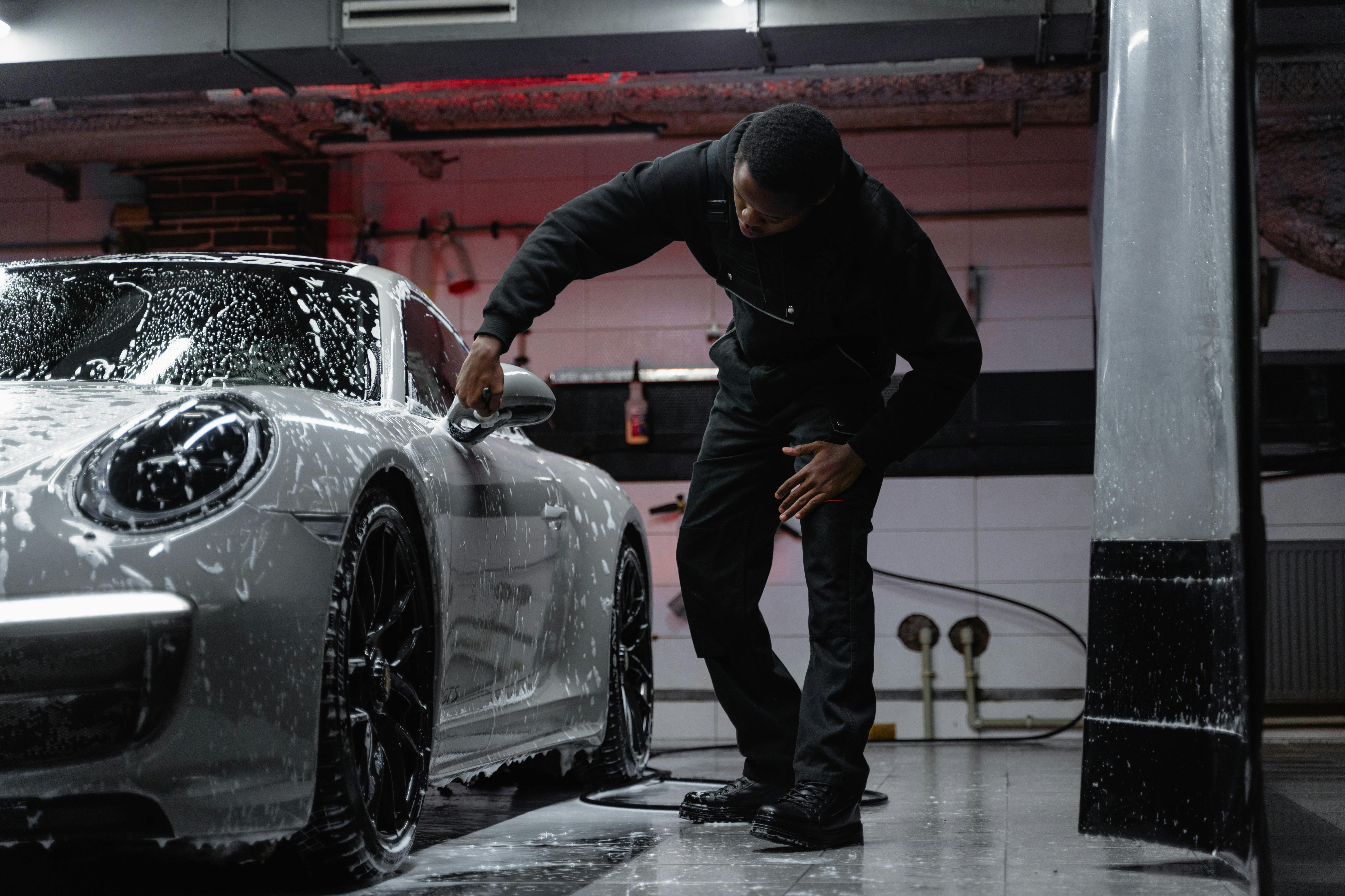 Professional hand washing a Porsche using microfiber mitt